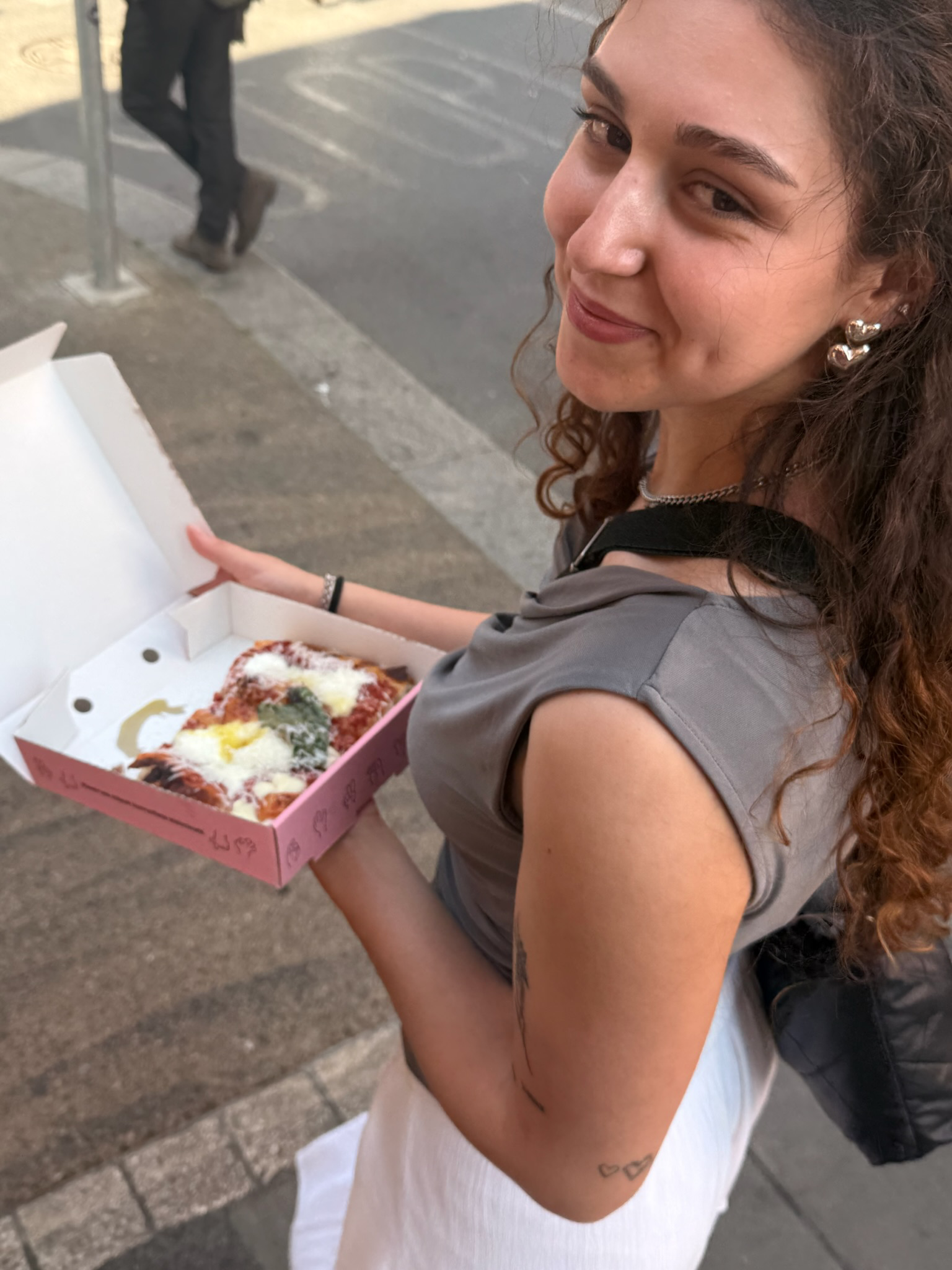 Leoni hält einen Pizzakarton mit Pizza